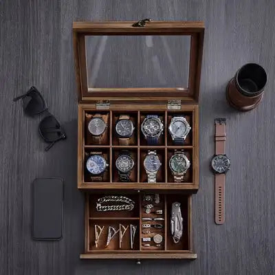 Drewniana witrynka na zegarki z szklaną pokrywą i zorganizowanymi przegródkami mieszczącymi wiele zegarków, bransoletek i akcesoriów.