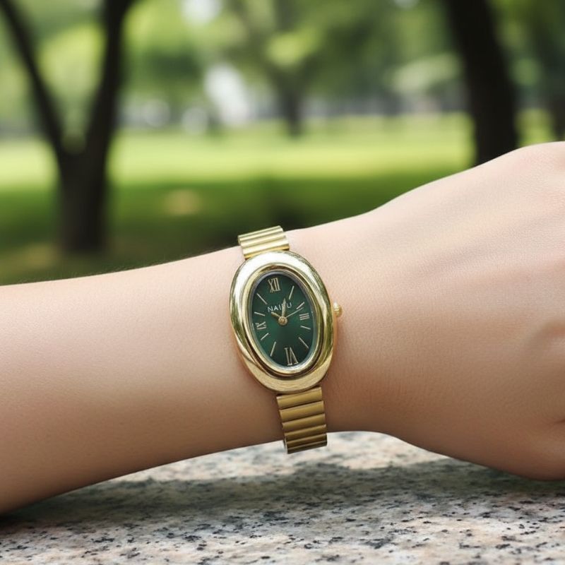 Owalny damski zegarek w złotym tonie z zieloną tarczą i rzymskimi cyframi