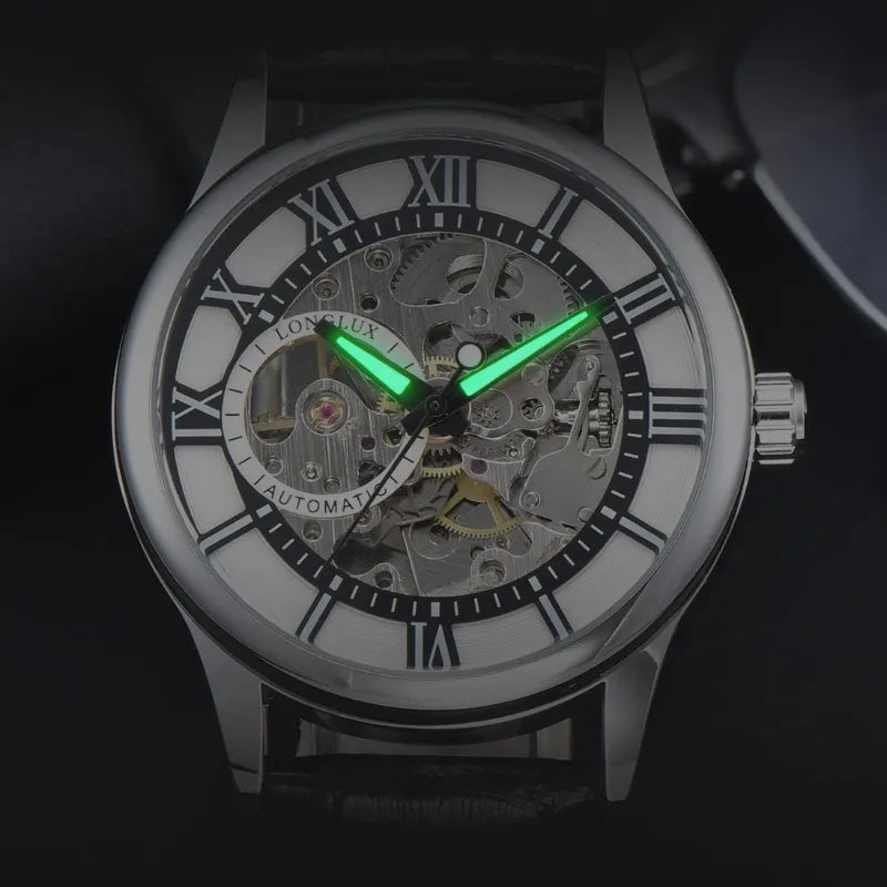 Srebrny szkieletowy zegarek mechaniczny z zielonymi wskazówkami i rzymskimi cyframi