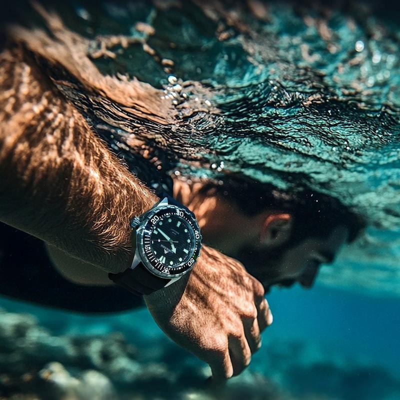 Szczupły czarny zegarek nurkowy na nadgarstku pływaka pod wodą