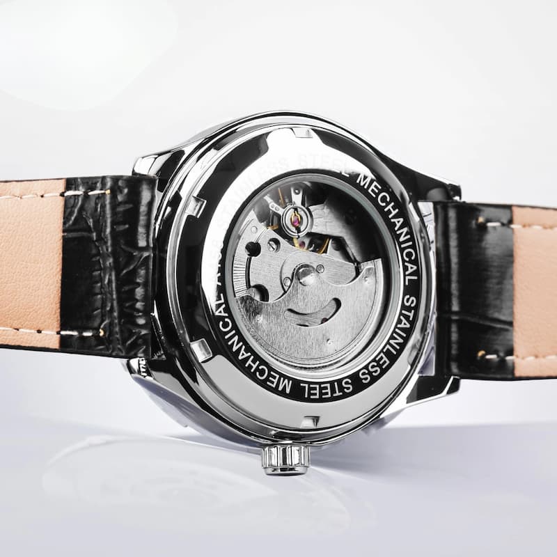 Srebrny stalowy zegarek mechaniczny z czarnym paskiem ze skóry imitującej krokodyla i beżową podszewką